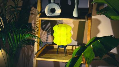 Yellow lamp on a wooden shelf with plants and an aesthetic background