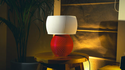 Modern red spiral base table lamp with white fluted shade, warm ambient lighting