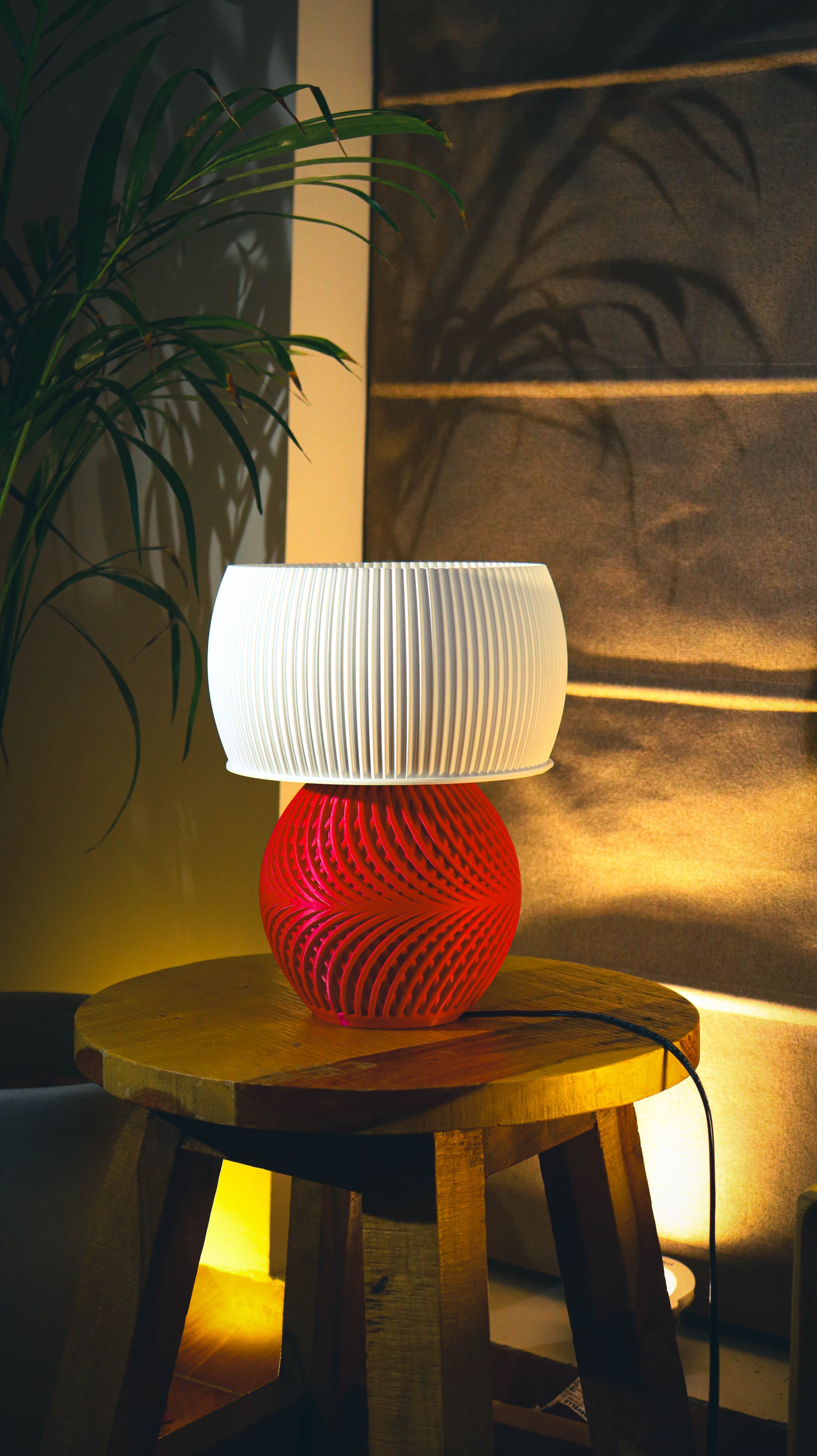 Modern red spiral base table lamp with white fluted shade, warm ambient lighting